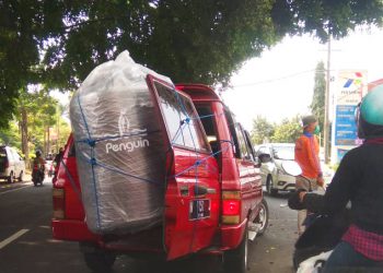 Sebuah mobil membawa tandon air, namun mungkin karena tidak cukup untuk masuk mobil, akhirnya sebagian besar bagiannya berada di luar kendaraan.