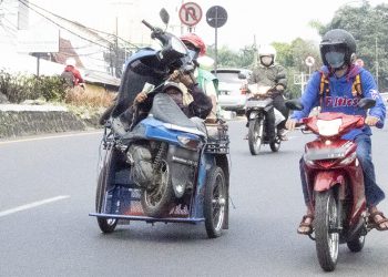 Mungkin cara mengangkut sepeda motor seperi ini bisa lebih menghemat biaya.