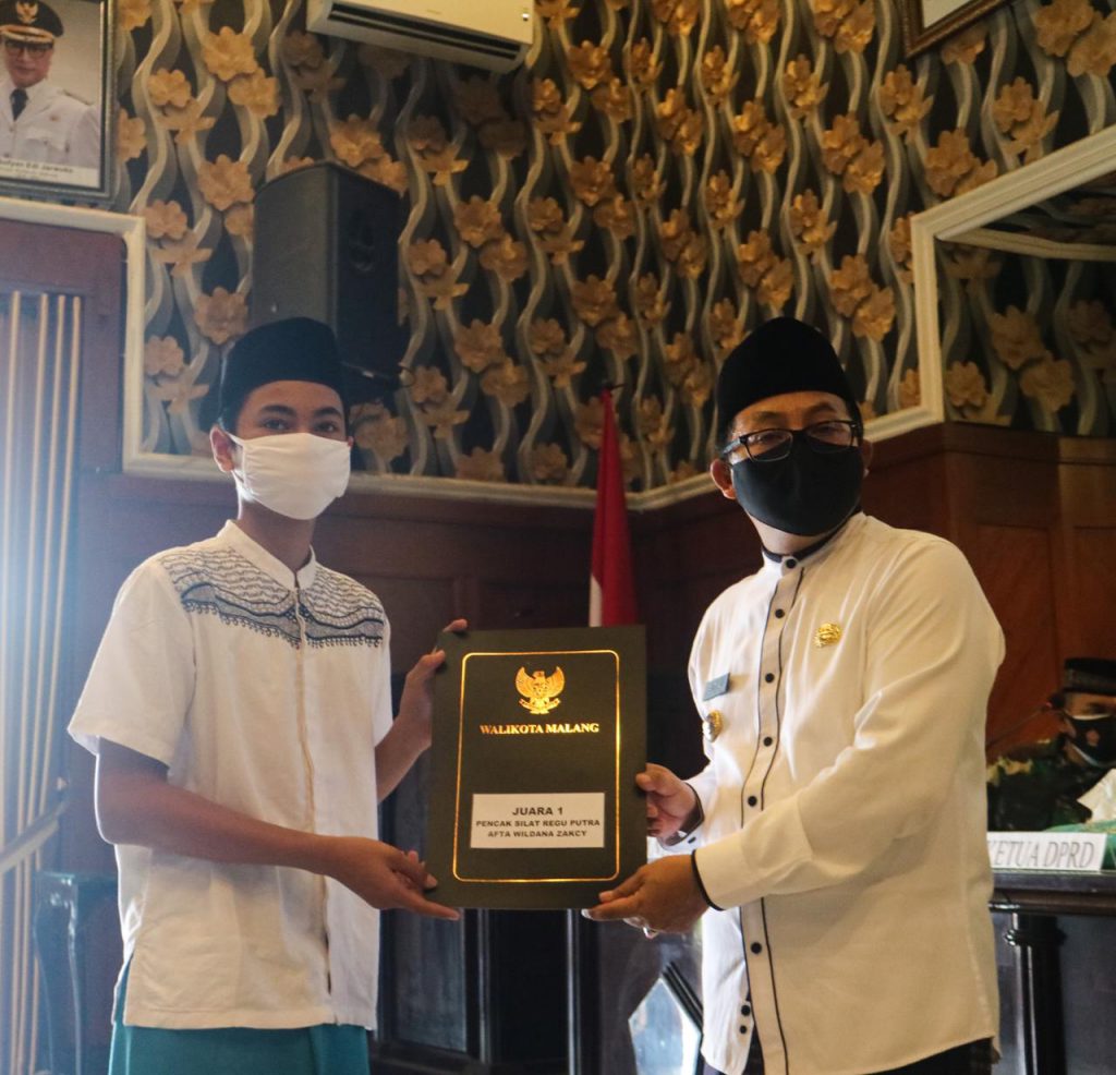 PRESTASI: Salah seorang santriwan mendapat penghargaan langsung dari Walikota Malang, Sutiaji. (Foto: Humas Pemkot Malang)