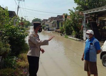 Kapolsek memantau kondisi banjir akibat luapan Kali Lamong, Kabupaten Gresik. (Foto: Sudasir Al Ayyubi/Javasatu.com)