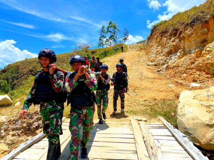 Satgas Yonif Mekanis 203/AK Tolong Warga Sakit dengan Cara Digotong